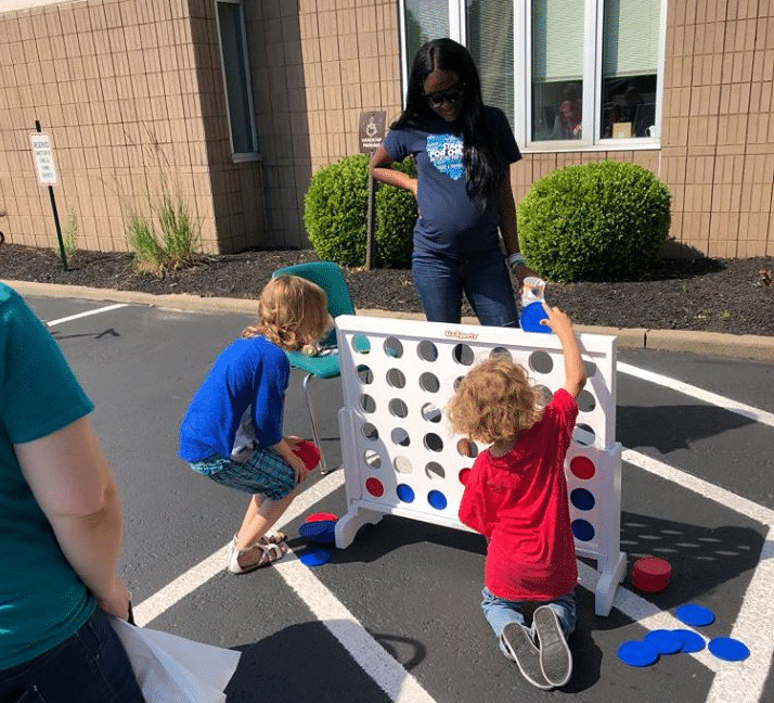 Kids playing connect four outside at NHS Family Services Block Party
